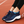 Donkerblauwe sportschoenen met witte zool en blauwe accenten op een atletiekbaan. Comfortabele dames sneakers, ideaal voor hardlopen en fitness.