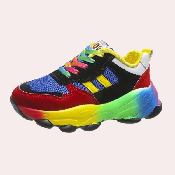 Kleurrijke sneaker met regenboogzool, blauwe mesh, rode en gele accenten. Trendy sportschoen voor kinderen, ideaal voor dagelijks gebruik.