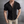 Zwarte herenpolo met korte mouwen, knoopsluiting en geribbelde textuur, gedragen door een man. Stijlvolle casual herenkleding.