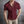 Man in wijnrode gebreide polo met korte mouwen, open kraag en beige broek, voor metalen achtergrond. Stijlvolle herenkleding, casual mode.