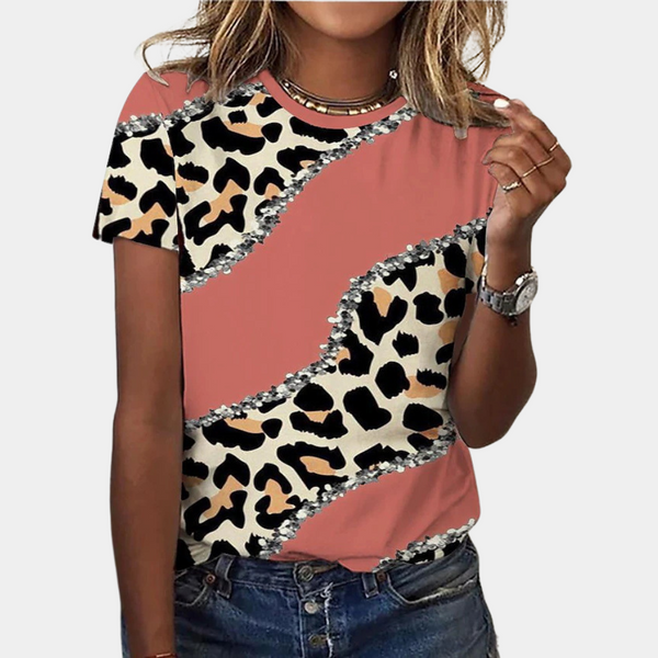 Vrouw draagt trendy T-shirt met luipaardprint en roze accenten, casual stijl. Perfect voor modebewuste vrouwen. Dameskleding, zomeroutfit.