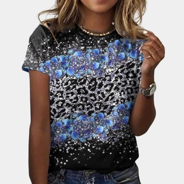 Vrouw draagt zwart T-shirt met blauwe bloemenprint en luipaardpatroon, casual mode, trendy dameskleding, korte mouwen, sieradenaccessoires.