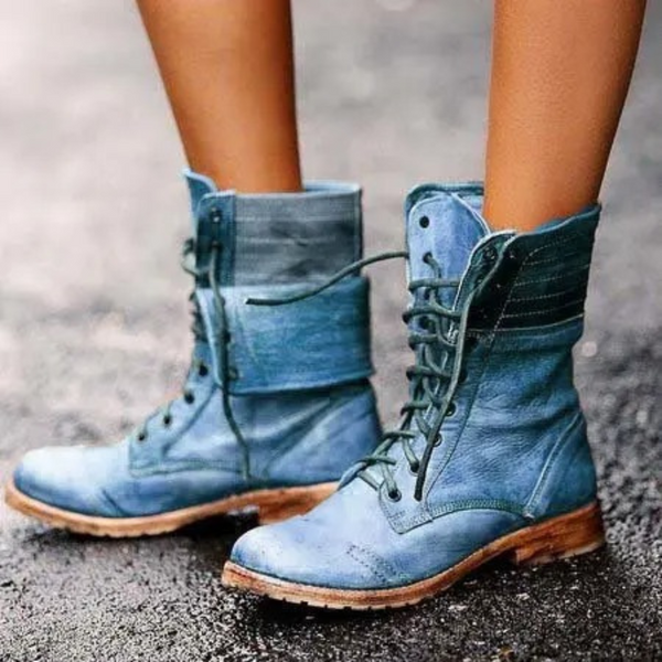 Blauwe leren laarzen met veters, gedragen op een natte straat. Stijlvolle dameslaarzen, casual mode, comfortabele schoenen voor dagelijks gebruik.