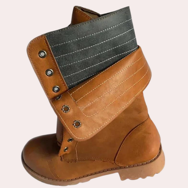 Bruine leren laars met opgerolde zwarte manchet, stevige zool en metalen knopen. Stijlvolle dameslaars, perfect voor herfstmode en casual outfits.