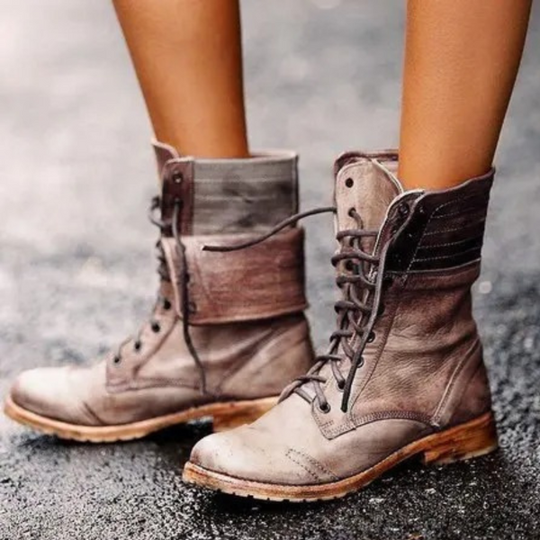 Khaki leren laarzen met veters, gedragen op natte straat. Stijlvolle damesmode, herfst schoenen, robuuste zool, casual outdoor look.