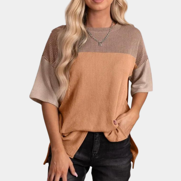 Vrouw draagt geribbelde, driekleurige trui in koraal, beige en bruin met korte mouwen. Modieuze dameskleding, casual stijl, trendy outfit.