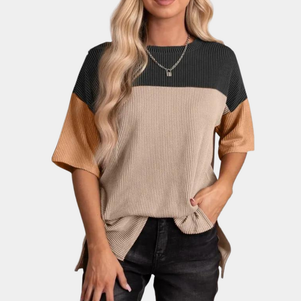 Vrouw draagt driekleurige ribgebreide trui met korte mouwen in donkergrijs, beige en camel. Modieuze dameskleding, casual stijl.