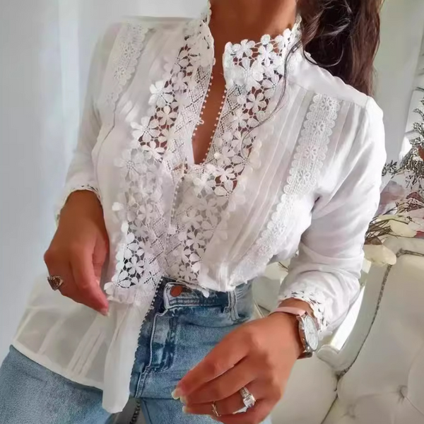 Witte kanten blouse met bloemenpatroon, gedragen door vrouw. Stijlvolle damesmode, perfect voor casual en chique outfits. Elegante en modieuze uitstraling.