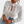 Vrouw draagt witte blouse met bloemenkant en lange mouwen, gecombineerd met blauwe jeans. Elegante damesmode, casual chique stijl.