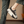 Zwarte platform sneaker met dikke zool, witte accenten en veters, gedragen door persoon in spijkerbroek. Trendy damesschoen, casual stijl.