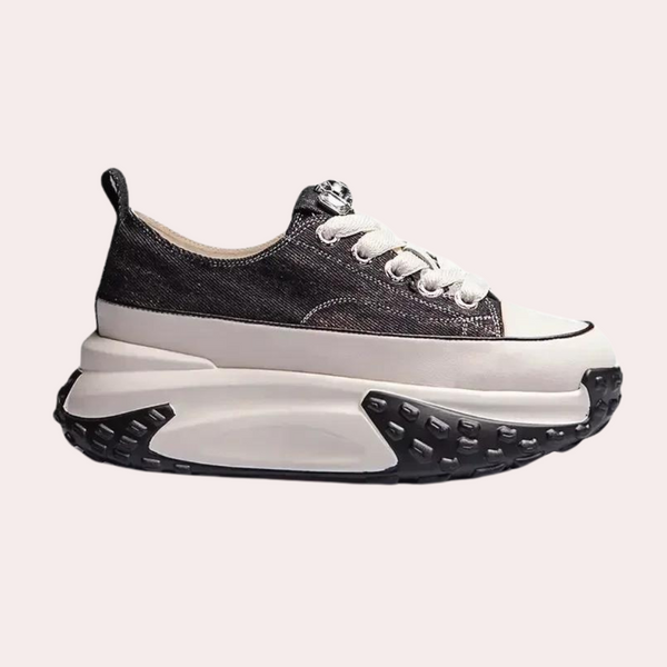 Zwarte platform sneaker met dikke zool, witte veters en canvas bovenwerk. Modieuze damesschoen, ideaal voor casual en trendy outfits.