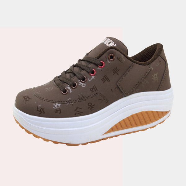 Bruine damessneaker met verhoogde witte zool, Koreaanse tekens, en rode veterogen. Comfortabele mode sneaker, ideaal voor dagelijks gebruik.