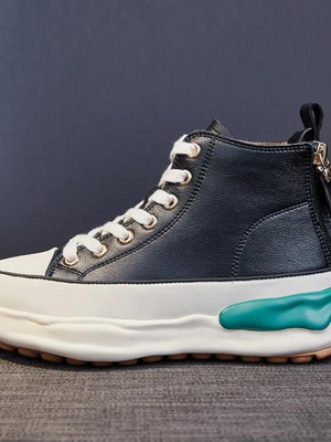Zwarte leren sneaker met dikke witte zool, turquoise detail en veters. Modieuze hoge sneaker voor casual en sportieve outfits.