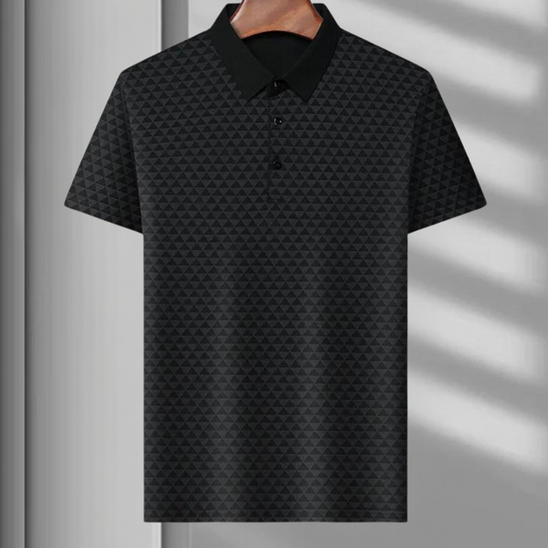 Zwarte polo met geometrisch patroon, korte mouwen en kraag, hangend aan houten hanger. Stijlvolle herenkleding, moderne casual look.