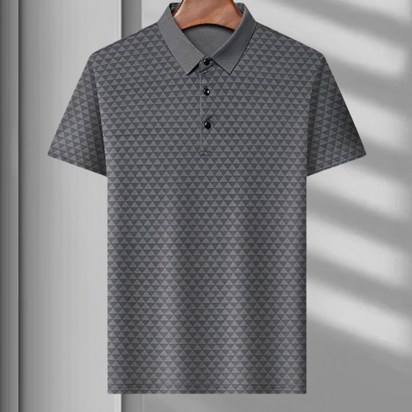 Grijze poloshirt met driehoekpatroon, korte mouwen en knoopsluiting, hangend aan een houten hanger. Perfect voor casual en zakelijke gelegenheden.