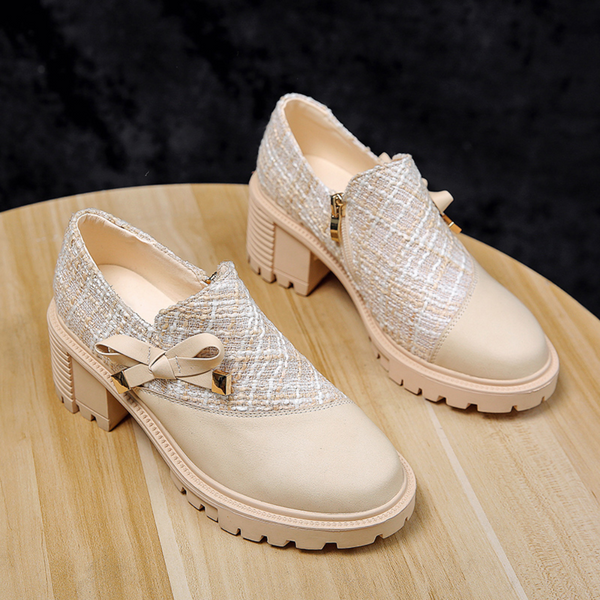 Beige damesschoenen met hak, tweed textuur en strikdetail op houten tafel. Modieuze, comfortabele schoenen voor dagelijks gebruik.