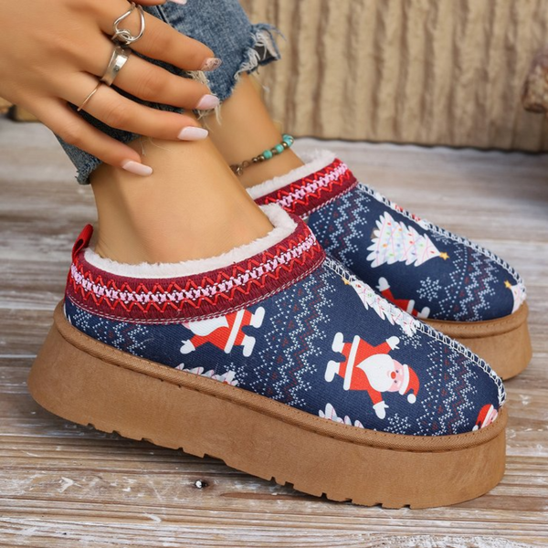 Blauwe kerstpantoffels met kerstman- en kerstboomprint, warme voering, dikke bruine zool, ideaal voor wintercomfort en feestelijke stijl.
