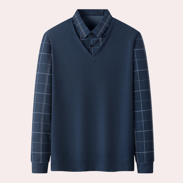 Donkerblauwe trui met V-hals en geruite mouwen, over een geruit overhemd. Stijlvolle herenkleding, moderne casual look.