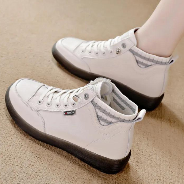 Witte hoge sneakers met zwarte zool en grijze gestreepte voering, merklabel "SHION", op beige tapijt. Modieuze casual schoenen voor dames.