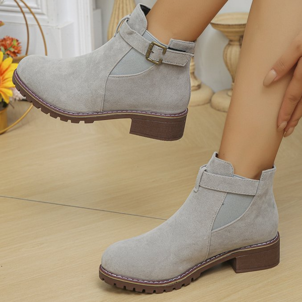 Grijze suède enkellaarsjes met gesp, lage hak en elastische inzet. Stijlvolle dameslaarzen voor herfstmode. Comfortabele en trendy schoenen.