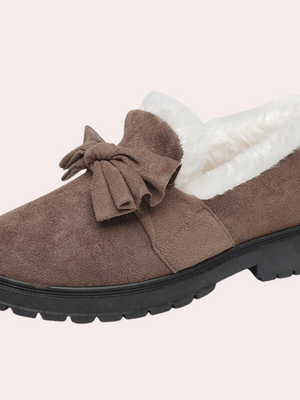 Bruine damesloafer met strik, warme voering en stevige zwarte zool. Perfect voor wintermode en comfort. Stijlvolle en praktische schoenen.