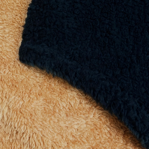 Donkerblauwe en beige teddy stof textuur, close-up. Zachte, pluizige materialen voor kleding of interieur. Trendy, warme stoffen voor wintermode.