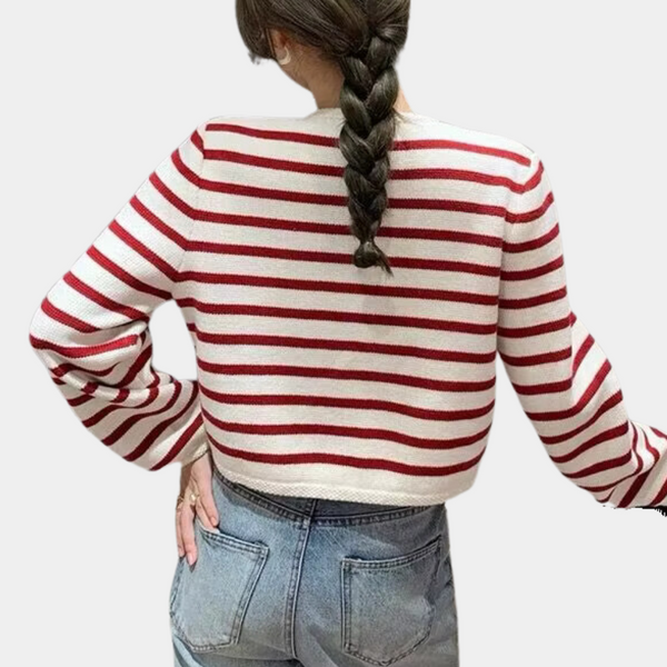 Achteraanzicht van vrouw in rood-wit gestreepte trui met lange mouwen, gecombineerd met blauwe jeans. Modieuze casual outfit.