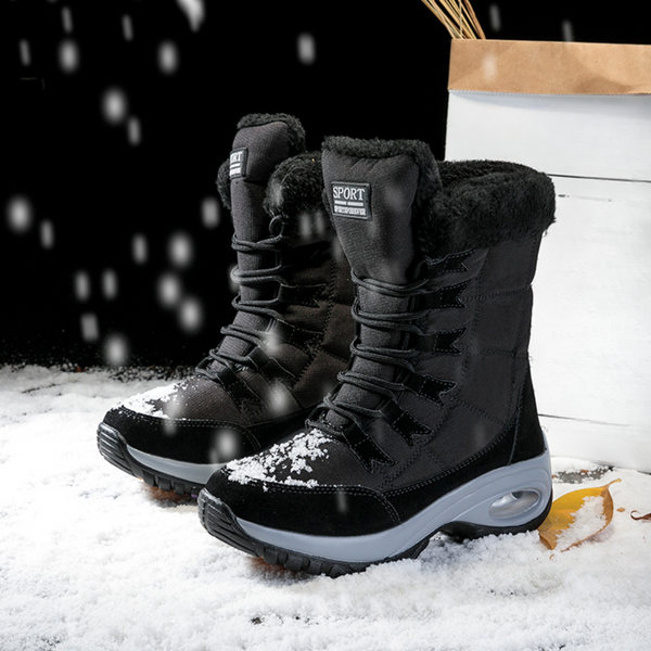 Zwarte winterlaarzen met bontvoering, sneeuwbestendig, op sneeuwachtergrond. Ideaal voor koude weersomstandigheden. Comfortabele en warme schoenen.