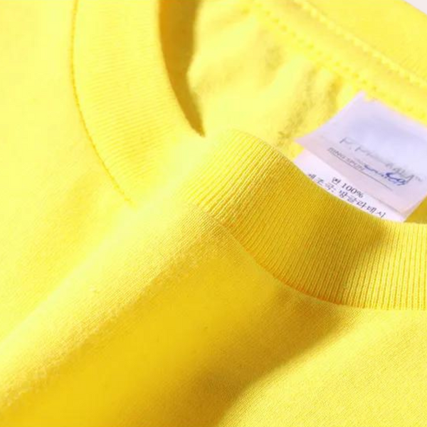 Gele katoenen T-shirt met label, close-up van de kraag en stoftextuur. Hoogwaardige casual kleding, modetrend, comfortabele pasvorm.