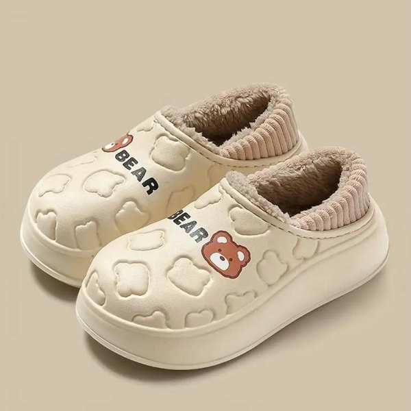 Beige kinderpantoffels met berenmotief, pluche voering en antislipzool. Comfortabele en warme sloffen voor kinderen. Perfect voor thuisgebruik.