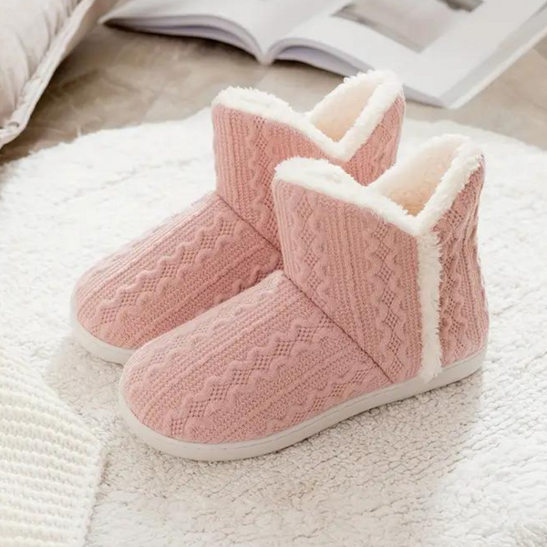 Roze gebreide pantoffels met witte voering, warme winter sloffen op een zachte witte mat, perfect voor comfort en stijl in huis.