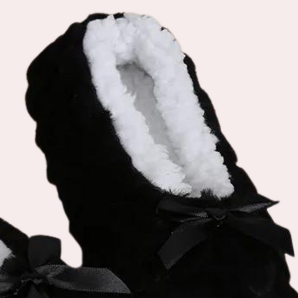 Zwarte pantoffel met witte pluche voering en strikje, comfortabele dames huisschoenen, warme winter sloffen, luxe zachte binnenkant.