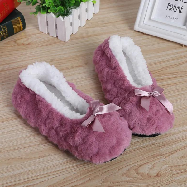 Roze pluche pantoffels met witte voering en strikje, perfect voor dames. Comfortabele huisschoenen, ideaal voor koude dagen. Stijlvol en warm.