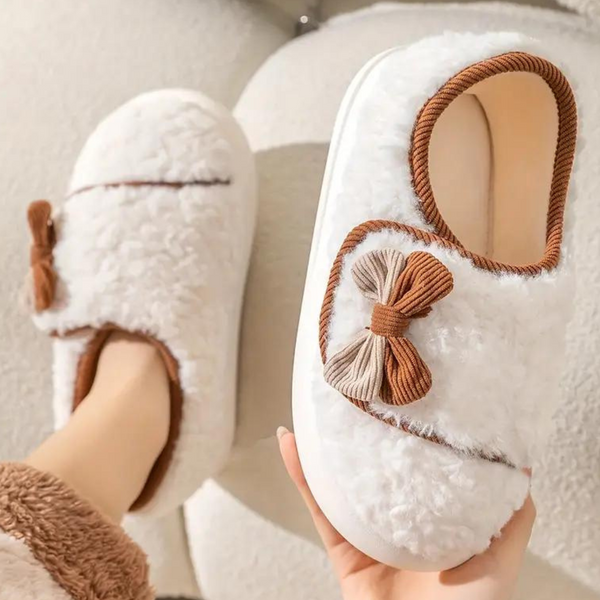 Witte pluche pantoffels met bruine strik en decoratieve rand, comfortabele winterse huisschoenen voor dames, warme en zachte binnenzool.
