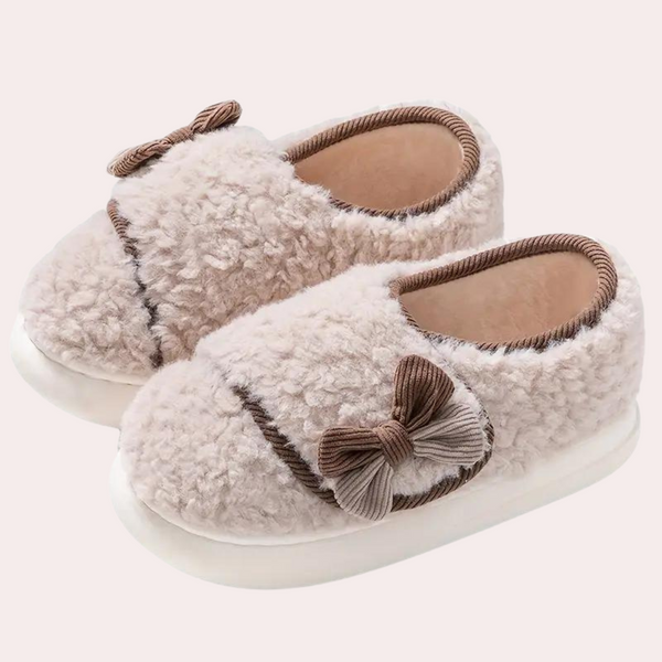 Pluche baby pantoffels met strik, licht koffie kleur, antislip zool. Perfect voor warme, comfortabele babyvoetjes. Ideaal als kraamcadeau.