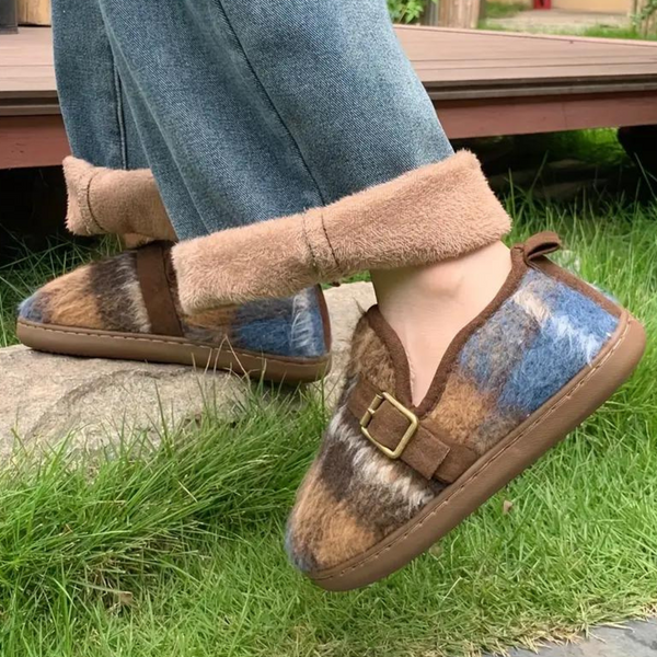 Pluizige pantoffels met bontpatroon en gesp, gedragen met opgerolde jeans. Comfortabele, warme huisschoenen voor binnen en buiten.