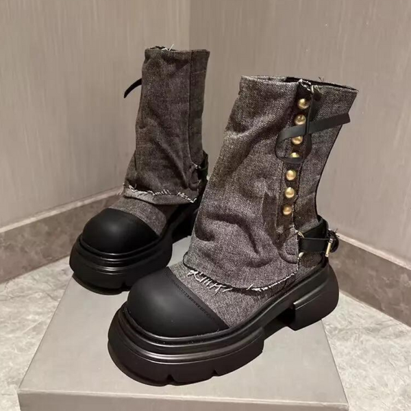 Zwarte enkellaarsjes met dikke zool, metalen studs en gescheurde denim stof. Trendy damesmode, robuuste laarzen, casual streetwear stijl.