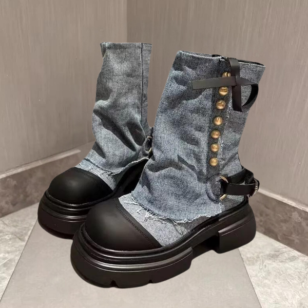 Blauwe denim laarzen met zwarte rubberen zolen, metalen knopen en riemdetails. Modieuze dameslaarzen, trendy en robuust ontwerp.