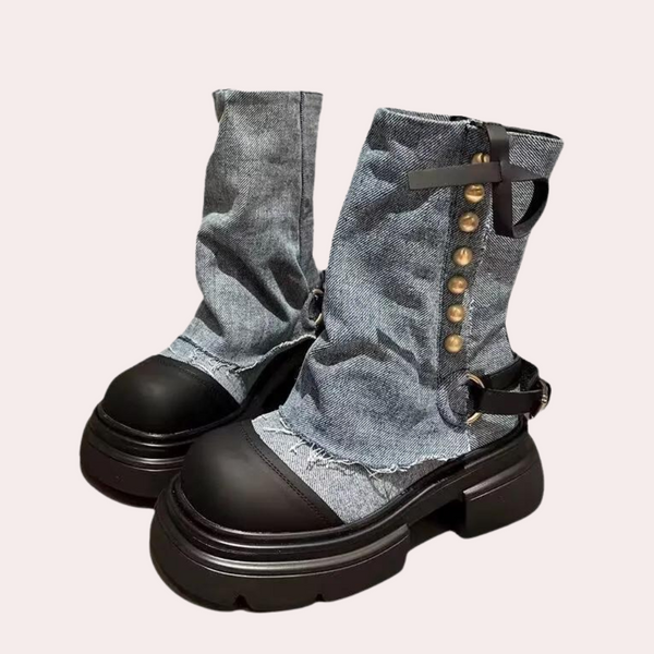 Blauwe denim laarzen met dikke zwarte zolen, metalen knopen en riemdetails. Trendy damesmode, stevige schoenen, casual stijl.
