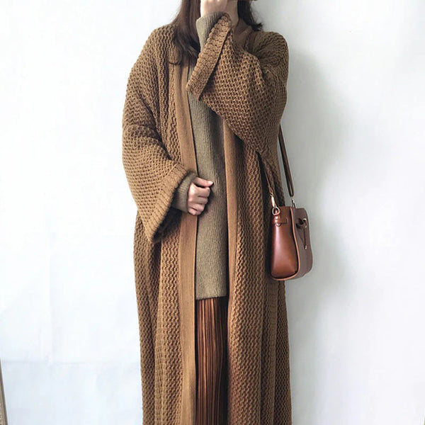 Vrouw in lange bruine gebreide jas met schoudertas, modieuze herfstkleding, comfortabele en stijlvolle damesoutfit, casual chic look.