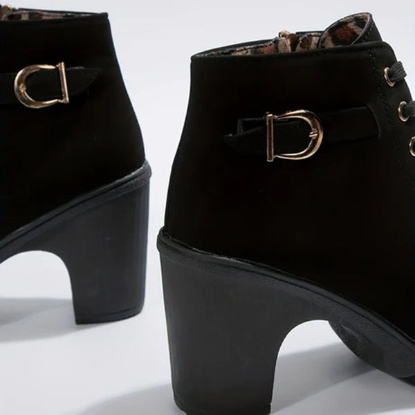 Zwarte enkellaarsjes met blokhak en gouden gespen, stijlvolle damesmode, trendy schoenen, herfst- en wintercollectie, elegant design.