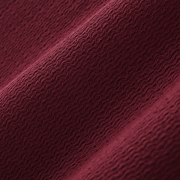 Bordeauxrode geribbelde stof close-up, textuur met golvend patroon, ideaal voor modeontwerp en interieurdecoratie. Luxe textielmateriaal.