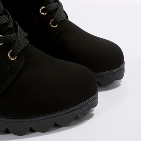 Zwarte leren laarzen met veters en stevige rubberen zolen, close-up. Modieuze dameslaarzen, ideaal voor herfst- en winterseizoenen.