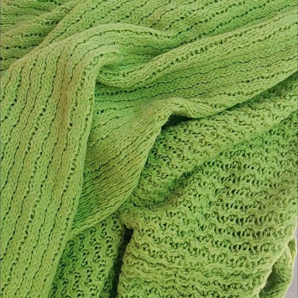 Felgroene gebreide stof close-up, met gedetailleerd patroon en textuur. Perfect voor mode, interieurdecoratie en ambachtelijke projecten.