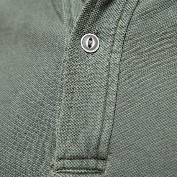 Groene polo met knoopsluiting, close-up van textuur en knoopdetail. Hoogwaardige katoenen stof, casual herenkleding, modieuze stijl.