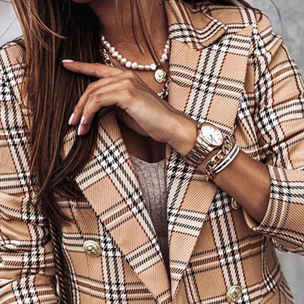 Vrouw in geruite blazer met parelketting en gouden horloge. Modieuze dameskleding, accessoires, herfstmode, stijlvolle outfit.
