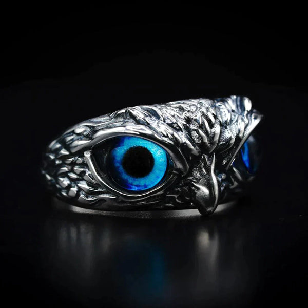 Zilveren uilenring met blauwe ogen, gedetailleerd ontwerp, glanzend metaal, unieke sieraden, dierenring, handgemaakt, stijlvolle accessoire.