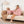 Vrouw en hond in roze fleece hoodies op bank, moderne woonkamer, vloerlamp, beige deken. Comfortabele kleding, huiselijke sfeer.