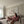 Vrouw en hond in roze dekens op beige bank in moderne woonkamer, ontspannen sfeer, minimalistisch interieur, gezelligheid, huiselijk comfort.