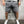 Grijze herenshorts met rafelige zoom, casual stijl, gedragen met witte sneakers. Comfortabele pasvorm, ideaal voor zomerse activiteiten.